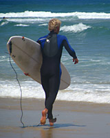 Surfer geht am Strand entlang